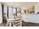 Dining area with wood table, chandelier, and views of the modern kitchen at 8976 Fox Dr # 101, Thornton, CO 80260