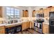 Modern kitchen featuring stainless steel appliances, wood cabinets, and a large window at 8976 Fox Dr # 101, Thornton, CO 80260