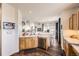 Open-concept kitchen with wooden cabinets, stainless steel dishwasher, and an island at 8976 Fox Dr # 101, Thornton, CO 80260