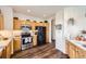 Bright kitchen features stainless steel appliances, wooden cabinets, and wood-look flooring at 8976 Fox Dr # 101, Thornton, CO 80260