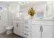 Well-lit bathroom featuring double vanity, modern fixtures, and a glass-enclosed shower at 7856 W 43Rd Pl, Wheat Ridge, CO 80033