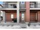 Townhome entrance featuring brick facade, covered porch, grill, and glass front door at 7856 W 43Rd Pl, Wheat Ridge, CO 80033