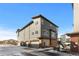 Exterior view of multi-story townhomes featuring gray siding, brick accents, and attached garages at 7856 W 43Rd Pl, Wheat Ridge, CO 80033