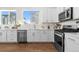 Bright kitchen features white cabinets, stainless steel appliances, hardwood floors, and natural light at 7856 W 43Rd Pl, Wheat Ridge, CO 80033