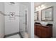 Bathroom featuring a glass-enclosed shower, dual sinks, and dark vanity at 9069 Renoir Dr, Littleton, CO 80126