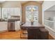 Bright kitchen with stainless steel appliances, white cabinets, and a large wooden dining table at 9069 Renoir Dr, Littleton, CO 80126