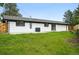 The home's back exterior displays a fresh white exterior, black trim, and a lush green lawn at 10320 W 35Th Ave, Wheat Ridge, CO 80033