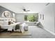 Bright bedroom featuring a ceiling fan, neutral carpet, and large window with views of the greenery outside at 10320 W 35Th Ave, Wheat Ridge, CO 80033