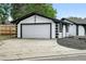Spacious detached garage with a large driveway, painted in a striking black and white color scheme at 10320 W 35Th Ave, Wheat Ridge, CO 80033
