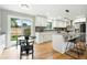 Contemporary kitchen with white cabinetry, an island with seating, and a dining area at 10320 W 35Th Ave, Wheat Ridge, CO 80033
