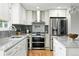 Modern kitchen featuring stainless steel appliances, marble countertops, and stylish white cabinetry at 10320 W 35Th Ave, Wheat Ridge, CO 80033