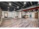 Finished basement with wood-look floors, exposed ceiling, and stylish wet bar at 6147 N Flanders St, Aurora, CO 80019