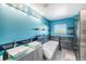 Bright turquoise bathroom with double vanity, soaking tub, stylish fixtures, and ample lighting at 6147 N Flanders St, Aurora, CO 80019