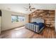 Sunlit bedroom featuring a wood accent wall, ceiling fan, and large window with neighborhood views at 6147 N Flanders St, Aurora, CO 80019