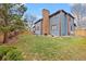 A beautiful blue two-story home features a backyard with a lush green lawn and mature trees at 16234 E Belleview Dr, Centennial, CO 80015