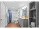 Bathroom featuring gray vanity with white countertop, shower over tub and storage shelves at 16234 E Belleview Dr, Centennial, CO 80015