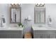 Beautiful bathroom featuring double sinks, marble countertops, and gray vanities at 16234 E Belleview Dr, Centennial, CO 80015