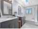 Stylish bathroom showcasing double sinks, a skylight, and a shower with glass door at 16234 E Belleview Dr, Centennial, CO 80015