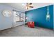 Stylish bedroom with blue accent wall, red chair, and decorative mirror at 16234 E Belleview Dr, Centennial, CO 80015