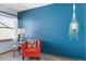 Stylish bedroom with blue accent wall, red chair, and decorative plants at 16234 E Belleview Dr, Centennial, CO 80015