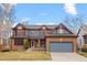 Charming two-story home featuring brick and blue siding, complemented by a well-maintained front yard and two-car garage at 16234 E Belleview Dr, Centennial, CO 80015