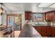 Bright kitchen features granite countertops, wood cabinets, and access to the outdoor patio area at 16234 E Belleview Dr, Centennial, CO 80015