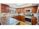 Modern kitchen with stainless steel appliances, granite countertops, and wood cabinets at 16234 E Belleview Dr, Centennial, CO 80015