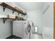 Functional laundry room with a washer, dryer, and ample shelving space at 16234 E Belleview Dr, Centennial, CO 80015