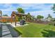 Large backyard with lush green grass, a wooden pergola, and a grill at 6604 S Dahlia Cir, Centennial, CO 80121