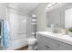 This bathroom features a combined tub and shower, a gray vanity, and stylish decor at 6604 S Dahlia Cir, Centennial, CO 80121