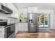 Modern kitchen with white cabinets, stainless steel appliances, and access to backyard at 6604 S Dahlia Cir, Centennial, CO 80121