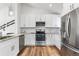 This kitchen features stainless steel appliances, white cabinets, and granite countertops at 6604 S Dahlia Cir, Centennial, CO 80121