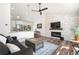 Bright living room with a cozy fireplace, modern ceiling fan, and wood-look flooring at 6604 S Dahlia Cir, Centennial, CO 80121