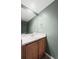 Neutral half bathroom features a wood vanity and framed mirror at 2002 E 102Nd Cir, Thornton, CO 80229