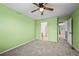 Bright bedroom featuring green walls, carpet, ceiling fan, and en suite bath at 2002 E 102Nd Cir, Thornton, CO 80229