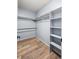 Walk-in closet featuring custom storage shelving, hanging racks, and wood floors at 2002 E 102Nd Cir, Thornton, CO 80229