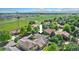 Wide aerial shot showcasing a neighborhood with mature landscaping, open fields, and mountain views in the distance at 1153 Village Cir, Erie, CO 80516