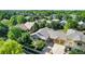 Aerial view of a suburban home with mature trees, a large driveway, and a three-car garage at 1153 Village Cir, Erie, CO 80516