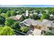Aerial view of a suburban home with mature trees, a large driveway, and a three-car garage at 1153 Village Cir, Erie, CO 80516