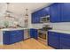 Kitchen features modern stainless steel appliances, designer backsplash, and blue cabinets at 1153 Village Cir, Erie, CO 80516