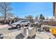 Overgrown backyard with a white car, carport, and various storage items at 8244 Clemson Ln, Westminster, CO 80031