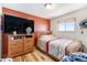 Cozy bedroom featuring hardwood floors, a comfortable bed, and a large window providing plenty of natural light at 8244 Clemson Ln, Westminster, CO 80031