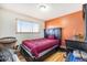 Cozy bedroom featuring warm orange accent wall, and a dark wood bed frame at 8244 Clemson Ln, Westminster, CO 80031