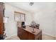 Dedicated home office space includes a large wooden desk, comfortable chair, and a bright window with natural light at 8244 Clemson Ln, Westminster, CO 80031