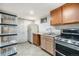Basement kitchen with basic appliances and adjacent shelving unit at 8244 Clemson Ln, Westminster, CO 80031