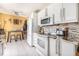 Well-lit kitchen features white cabinetry, modern appliances, and a dining nook perfect for casual meals at 8244 Clemson Ln, Westminster, CO 80031