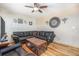 Comfortable living space featuring hardwood floors, a sectional sofa, and a decorative wall clock at 8244 Clemson Ln, Westminster, CO 80031