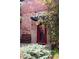 Brick building featuring a stylish red door and lovely landscaping at 3033 Blake St # 109, Denver, CO 80205