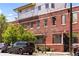 Street view of apartment building, showing brick facade, greenery, and parked vehicles at 3033 Blake St # 109, Denver, CO 80205