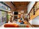 Inviting living room with exposed brick, wood beams, fireplace, and a comfortable orange velvet sofa at 3033 Blake St # 109, Denver, CO 80205